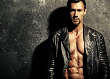 seksi yakışıklı moda erkek model adam portresi Studio gri grunge duvarda poz siyah bisikletçinin deri ceket giymiş. Metroseksüel