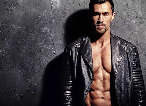 seksi yakışıklı moda erkek model adam portresi Studio gri grunge duvarda poz siyah bisikletçinin deri ceket giymiş. Metroseksüel
