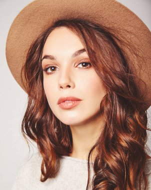 Genç şık gülen kız modeli gri rahat yaz giysileri ile doğal makyaj gri arka plan üzerinde izole kahverengi şapkalı portresi. Kameraya bakarak