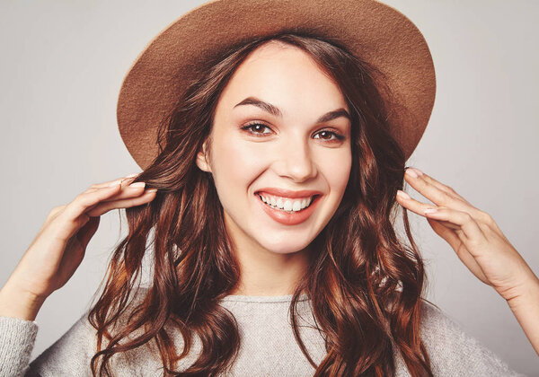 Portrait of young stylish laughing girl model in gray casual summer clothes in brown hat with natural makeup isolated on gray background. Looking at camera