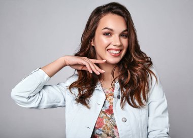 Genç şık gülen kız modeli renkli rahat yaz giysileri ile doğal makyaj gri arka plan üzerinde izole portresi. Kameraya bakarak