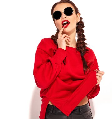 Genç mutlu gülümseyen kadın modeli ile parlak makyaj ve renkli dudakları iki boynuzu ve güneş gözlüğü üzerinde beyaz izole kırmızı yaz giysileri ile. Delirmek ve ağzını dokunmadan