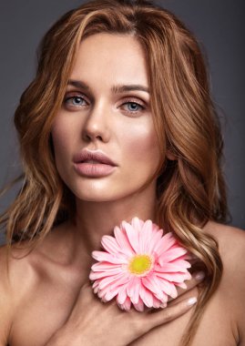 Genç sarışın kadın modeli ile doğal makyaj ve parlak pembe gerbera çiçek studi içinde poz ile mükemmel cilt güzellik moda portre