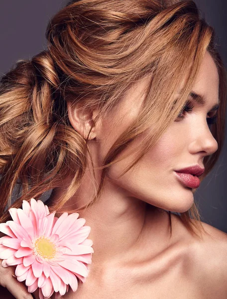 自然化粧品で若い金髪女性モデルとストゥディでポーズをとって明るいピンクのガーベラの花の完全な皮膚の美容ファッションの肖像画 — ストック写真