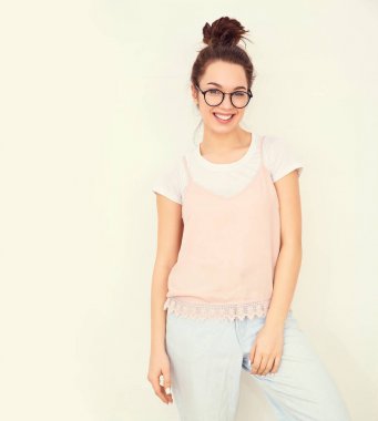 Genç güzel esmer kadın kız modeli renkli yaz pembe hipster giysileri duvara yakın poz çıplak makyaj ile portresi. Mutlu bir şekilde kamera arıyorum ve deli gidiyor 