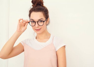 Genç güzel esmer kadın kız modeli renkli yaz pembe hipster giysileri duvara yakın poz çıplak makyaj ile portresi. Mutlu bir şekilde kamera arıyorum ve deli gidiyor 