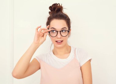 Genç güzel esmer kadın kız modeli renkli yaz pembe hipster giysileri duvara yakın poz çıplak makyaj ile portresi. Delirmek 