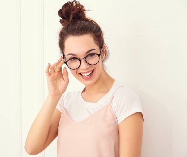 Genç güzel esmer kadın kız modeli renkli yaz pembe hipster giysileri duvara yakın poz çıplak makyaj ile portresi. Mutlu bir şekilde kamera arıyorum ve deli gidiyor 