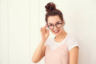 Genç güzel esmer kadın kız modeli renkli yaz pembe hipster giysileri duvara yakın poz çıplak makyaj ile portresi. Mutlu bir şekilde kamera arıyorum ve deli gidiyor 