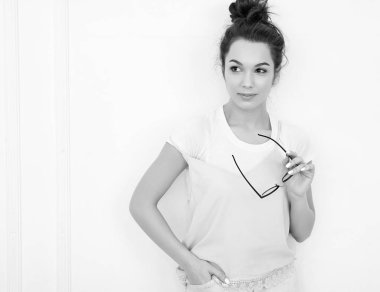 Genç güzel esmer kadın kız modeli renkli yaz pembe hipster giysileri duvara yakın poz çıplak makyaj ile portresi. Mutlu bir şekilde kamera arıyorum ve deli gidiyor 