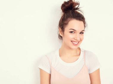 Genç güzel esmer kadın kız modeli renkli yaz pembe hipster giysileri duvara yakın poz çıplak makyaj ile portresi. Mutlu bir şekilde kamera arıyorum ve deli gidiyor 