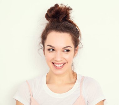 Genç güzel esmer kadın kız modeli renkli yaz pembe hipster giysileri duvara yakın poz çıplak makyaj ile portresi. Mutlu bir şekilde kamera arıyorum ve deli gidiyor 