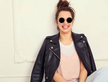 Genç güzel esmer kadın kız modeli ile çıplak makyaj duvara yakın poz güneş gözlüğü yaz hipster motorcu deri ceket elbise giyiyor portresi. Delirmek 