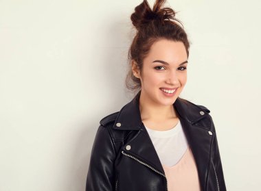Genç güzel esmer kadın kız modeli ile çıplak makyaj duvara yakın poz yaz hipster motorcu deri ceket elbise giyen portresi. Delirmek 