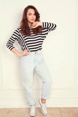 Genç güzel esmer kadın kız modeli yaz hipster giysileri duvara yakın poz çıplak makyaj ile portresi. Delirmek 