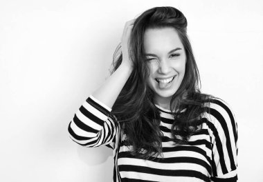 Genç güzel esmer kadın kız modeli yaz hipster giysileri duvara yakın poz çıplak makyaj ile portresi. Göz kırpıyor ve dilini gösteren