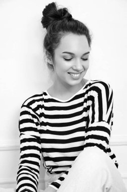 Genç güzel esmer kadın kız modeli yaz hipster giysileri duvara yakın poz çıplak makyaj ile portresi. Katta oturan