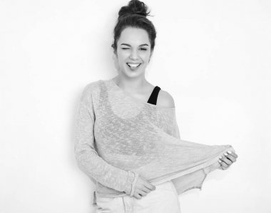 Genç güzel esmer kadın kız modeli yaz hipster giysileri duvara yakın poz çıplak makyaj ile portresi. Göz kırpıyor ve dilini gösteren