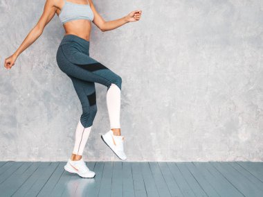 Spor kıyafetleri içindeki spor elbiseli kadın portresi. Spor kıyafetler giyen genç bir kadın. Mükemmel bronzlaşmış vücutlu güzel bir model.
