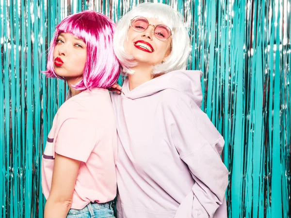 ウィッグと赤い唇の2人の若いセクシーなヒップスターの女の子 夏の服の美しい流行の女性 スタジオで青銀光沢のあるチンセルの背景にポーズケアフリーモデル — ストック写真