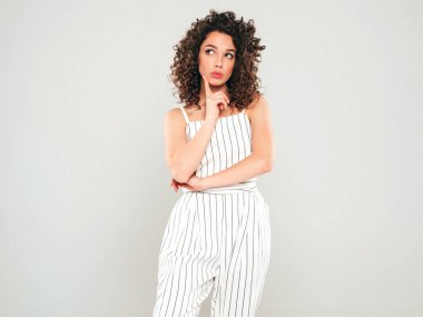 Kıvırcık saçlı, güzel bir mankenin portresi. Yazın hippi kıyafetleri giymiş. Tasasız bir kız, kafasında bir şeyler kuruyor.