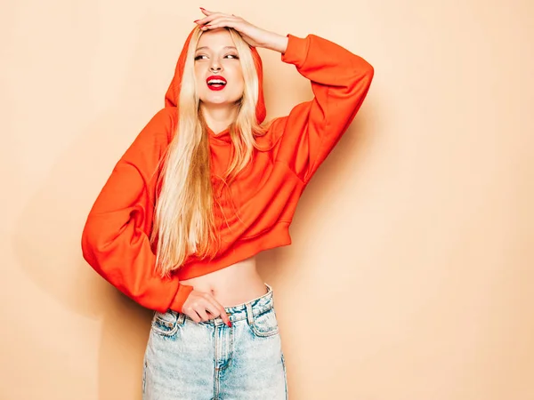 若い美しいヒップスター悪い女の子の肖像でトレンディーな赤い夏のパーカーと彼女の鼻の中にイヤリング スタジオでポーズセックス屈託のない笑顔ブロンドの女性 ポジティブモデル — ストック写真
