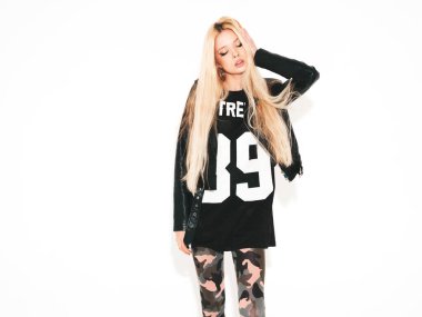 Genç, güzel, hippi, siyah deri ceketli, şık, daracık asker pantolonu giymiş kötü kız. Burnunda küpe olan bir model. Stüdyoda poz veren kaygısız bir kadın.