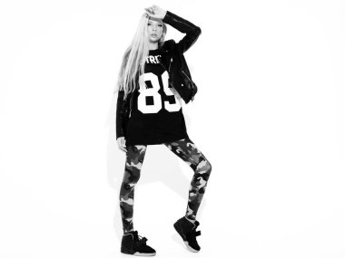 Genç, güzel, hippi, siyah deri ceketli, şık, daracık asker pantolonu giymiş kötü kız. Burnunda küpe olan bir model. Stüdyoda poz veren kaygısız bir kadın.