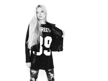 Genç, güzel, hippi, siyah deri ceketli, şık, daracık asker pantolonu giymiş kötü kız. Burnunda küpe olan bir model. Stüdyoda poz veren kaygısız bir kadın.