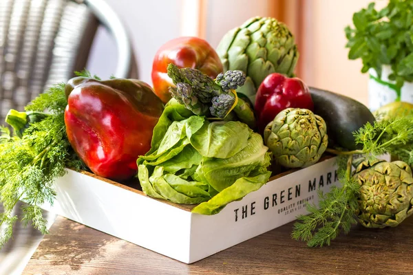 Varietà di verdure verdi e frutta in una cassa sul tavolo — Foto Stock