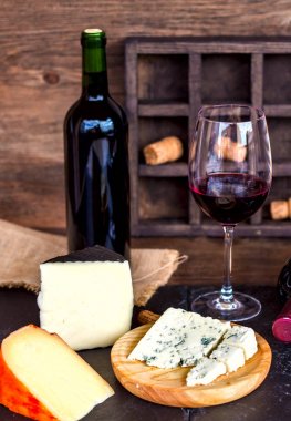 Kırmızı şarap ve peynir ahşap masa üzerinde. Kırsal tarzı