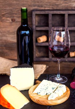 Kırmızı şarap ve peynir ahşap masa üzerinde. Kırsal tarzı