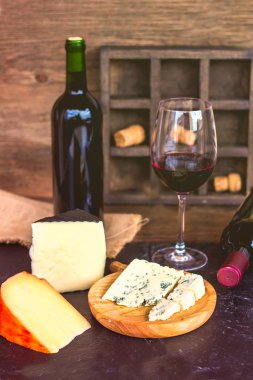 Kırmızı şarap ve peynir ahşap masa üzerinde. Kırsal tarzı