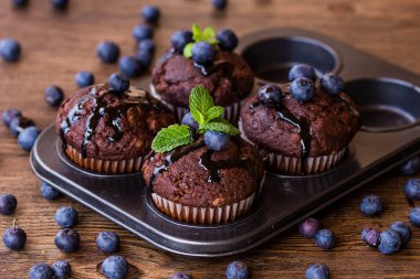 Çikolata şurubu, yaban mersini ve nane bir ahşap arka plan ile çikolatalı kek