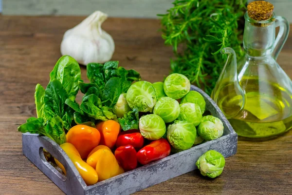 Verduras variadas pimienta, CABBAJO, cebollas y aceite de oliva sobre un fondo de madera —  Fotos de Stock