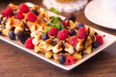 Ahududu, çikolata ve bir plaka üzerinde şurubu ile Belçika waffle.