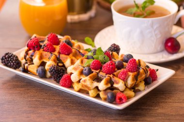 Ahududu, çikolata ve bir plaka üzerinde şurubu ile Belçika waffle.