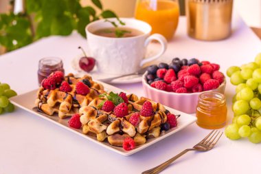 Ahududu, çikolata ve bir plaka üzerinde şurubu ile Belçika waffle.