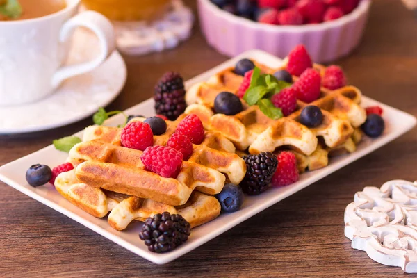 Belgica waffles com framboesas, chocolate e xarope em um prato . — Fotografia de Stock