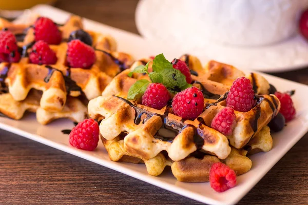 Belgium waffles with raspberries, chocolate and syrup on a plate. — Stock Photo, Image