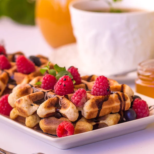 Gaufres belges aux framboises, chocolat et sirop sur une assiette . — Photo