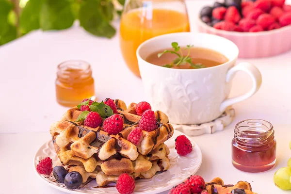 Belgium waffles with raspberries, chocolate and syrup on a plate. — Stock Photo, Image