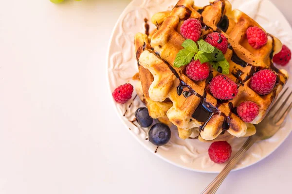 Gaufres belges aux framboises, chocolat et sirop sur une assiette . — Photo