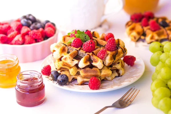 Belgische Waffeln mit Himbeeren, Schokolade und Sirup auf einem Teller. — Stockfoto