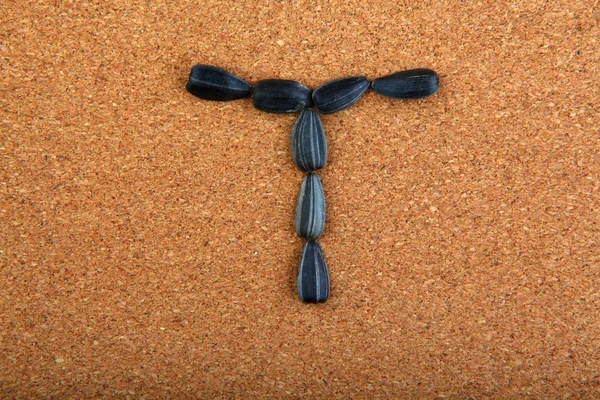黒ヒマワリ種子アルファベットの木製の背景 — ストック写真