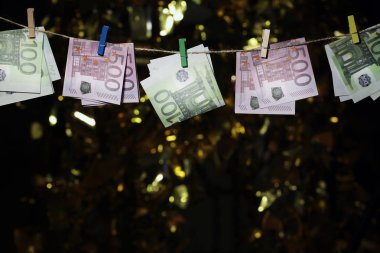 money banknote clothespin gold bokeh 