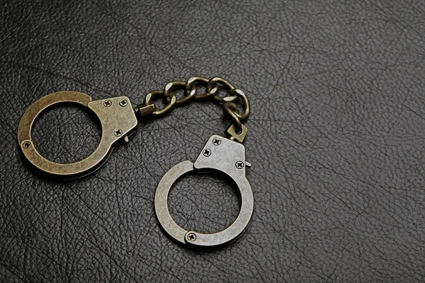 Iron Handcuffs Dark Leather Background — Stock Photo, Image