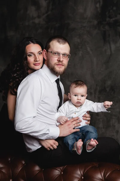 Portrét mladé rodiče a chlapeček na tmavě backgroundnd — Stock fotografie