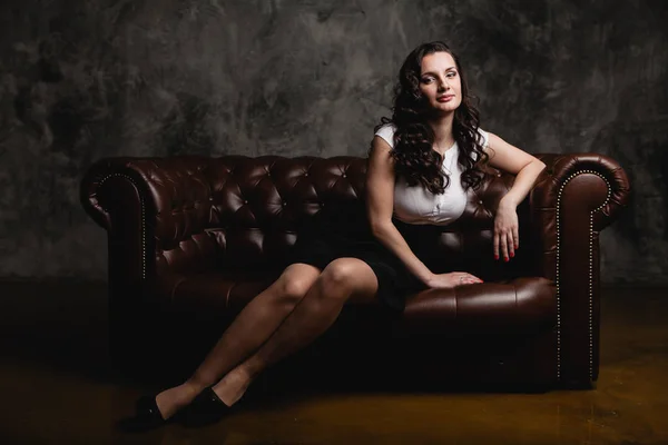 Красивая женщина сидит на диване — стоковое фото