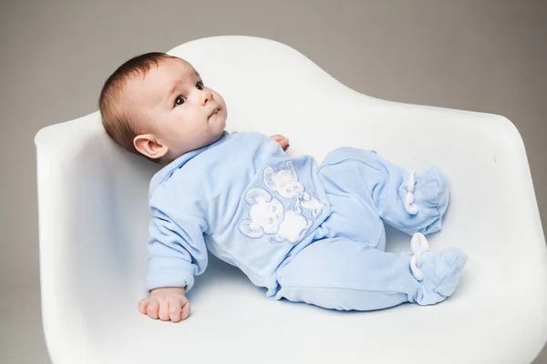 Little boy in blue clothes on chair — Stock Photo, Image